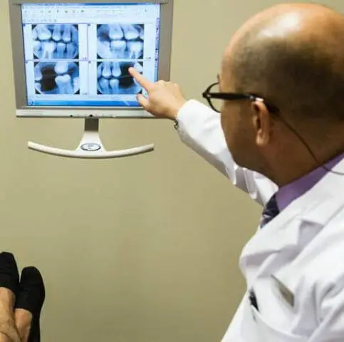 Dentist Dr Manuel at Sierra Dental Care in Modesto shows a patient their dental x-rays.